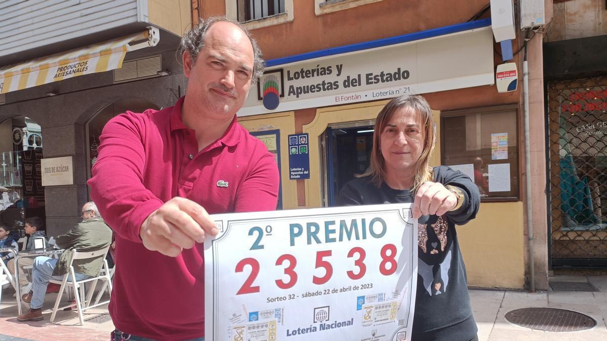 Luis Gutiérrez y Ana Valdés, con el cartel del premio, ante su administración de Loterías de la calle Fierros.