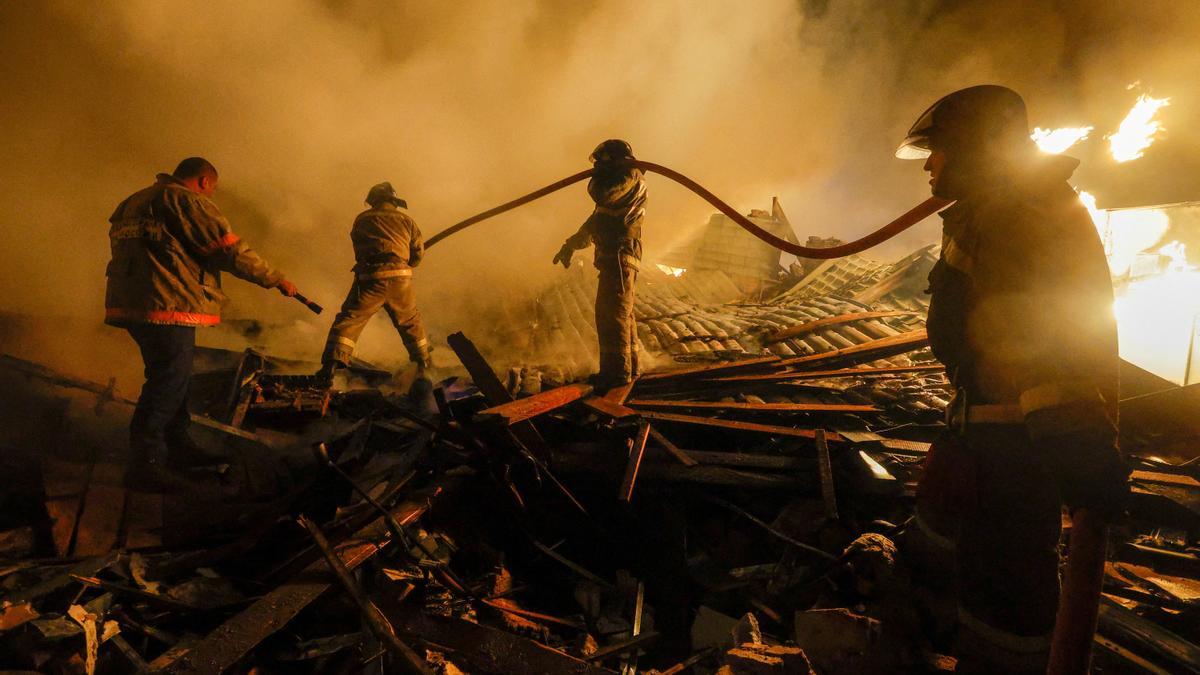 Agentes de bomberos trabajan en la extinción de un incendio provocado por un misil en el Donbás.