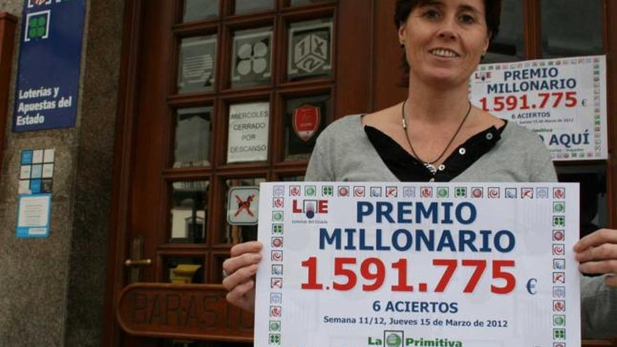 Amalia Gil, a la puerta del bar Asturias con el cartel que anuncia el premio.