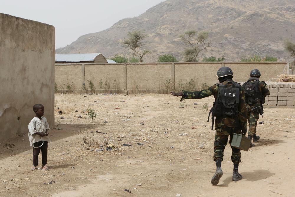 Soldados cameruneses del BIR, que combaten contra Boko Haram, piden a un niño que se mantenga alejado en Kerawa, Camerún.