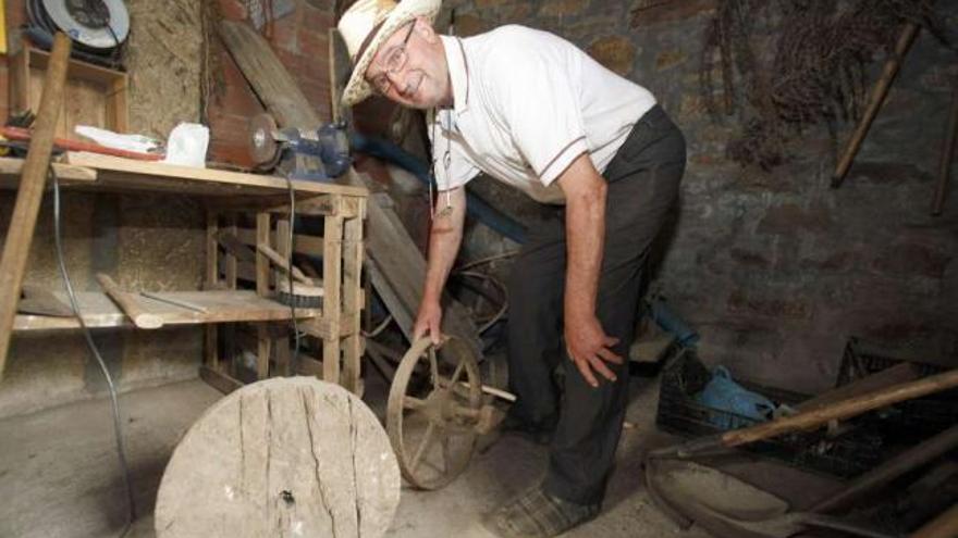 El propietario junto a la rueda de madera de la primera carretilla de la casa.  // Bernabé/Gutier