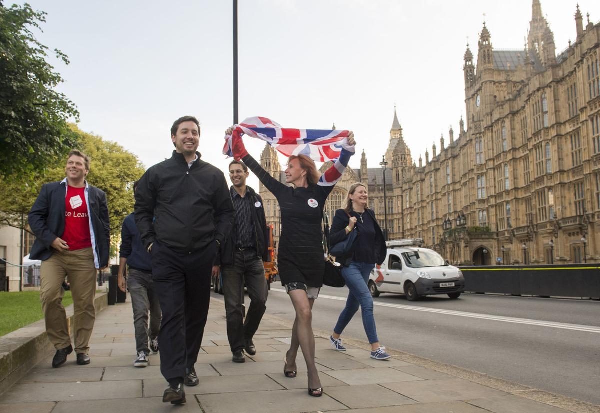 Partidarios de abandonar la UE celebran el resultado del referéndum mientras pasan frente al Parlamento, en Londres.