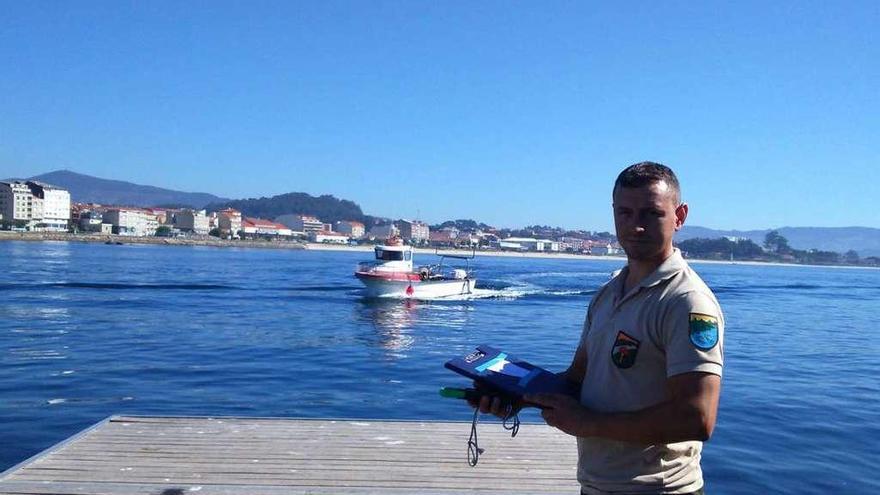 Miguel Rodal, vigilante del marisqueo a flote, a la espera de un barco, ayer, en el muelle de Cangas. // G.N.