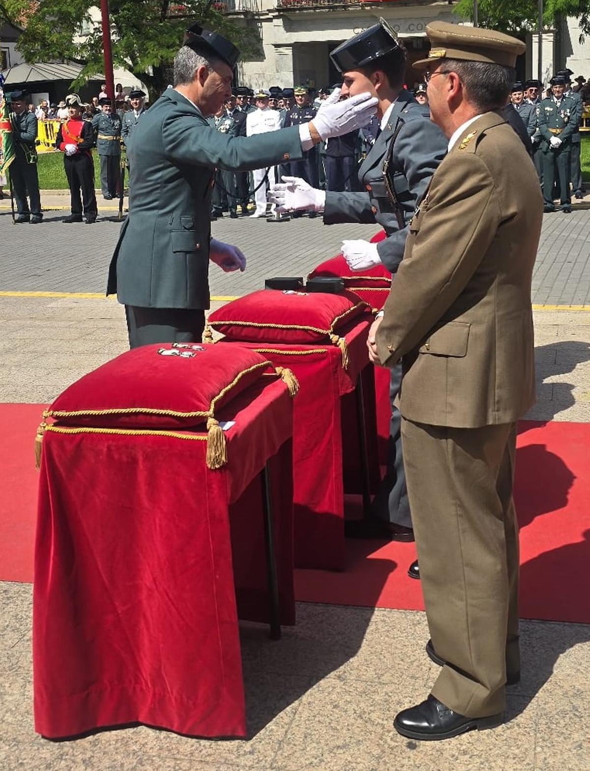 El guardia civil José Antonio Quintas recibe una condecoración de manos de su hijo Pablo, agente en prácticas.