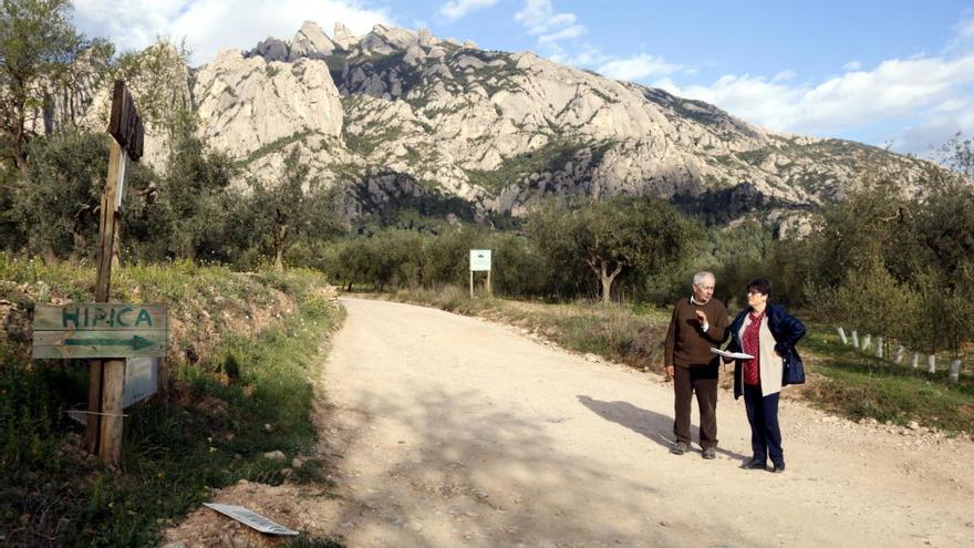 Dos dels opositors al projecte del càmping, Jaume Jorba i Gemma Estrada, a costat dels terrenys on s&#039;ha de construir, als peus de Montserrat