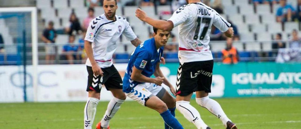 Edu Bedia, entre dos jugadores del Albacete en el partido disputado ayer en el Tartiere. maría gómez