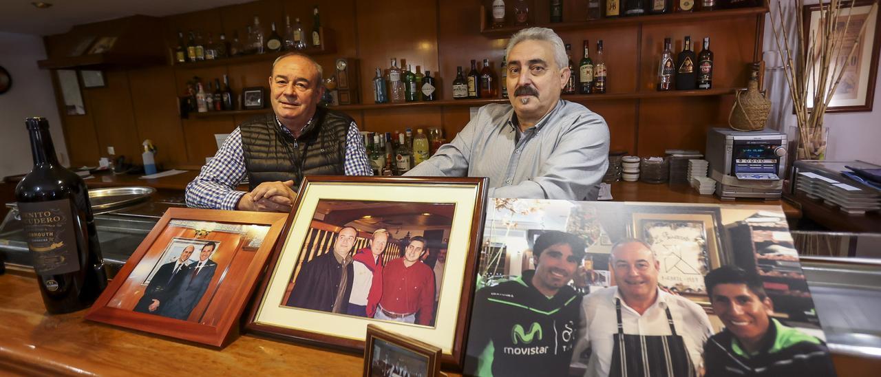 Juan José y Ramón tras la barra, con algunas fotos de comensales famosos.