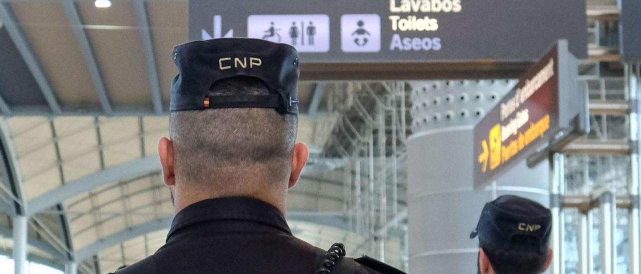 Imagen de dos policías nacionales en la terminal del aeropuerto de Alicante-Elche. | ÁXEL ÁLVAREZ