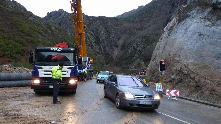 Los primeros coches que cruzaron, ayer, la zona del argayo en la carretera del Pozo de las Mujeres Muertas.