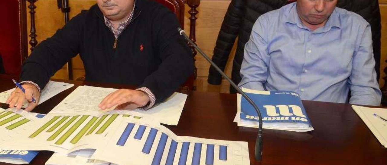 Xurxo Charlín, a la izquierda, examina unos gráficos estadísticos en un pleno de Cambados. // Noé Parga
