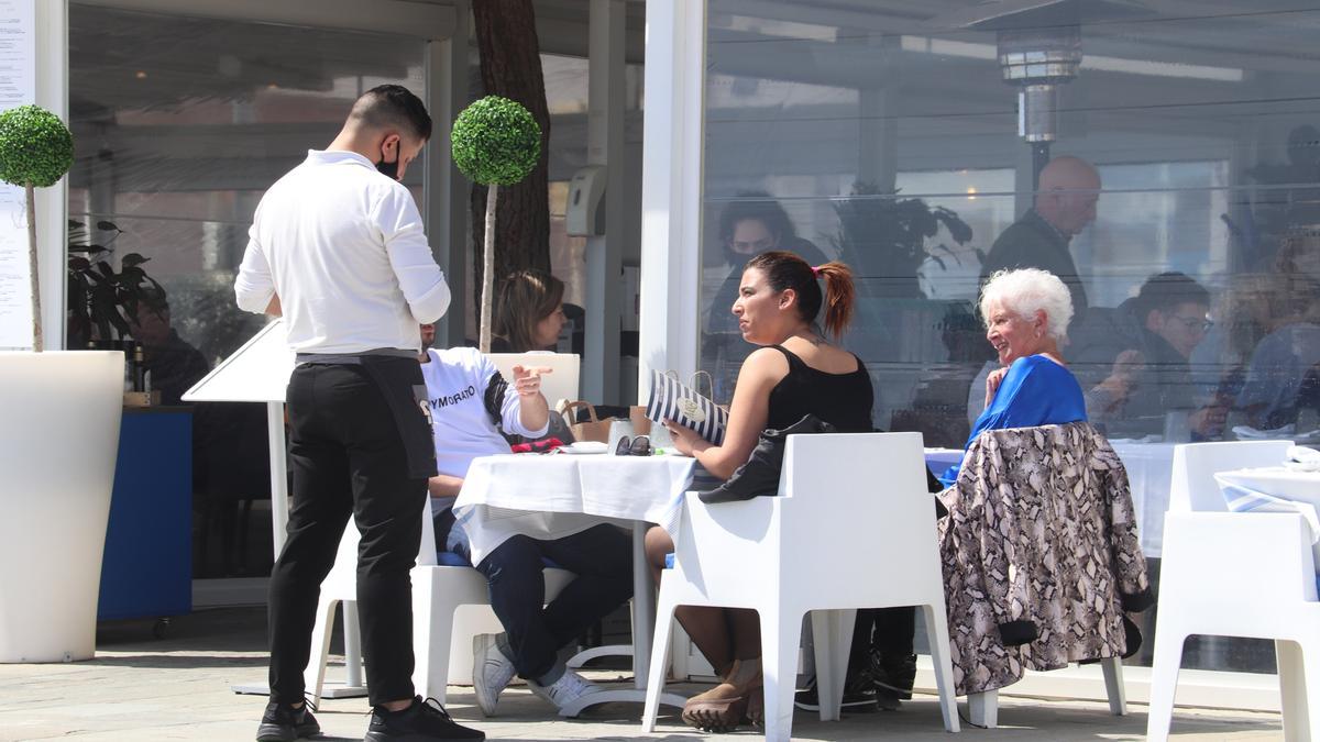 Un cambrer pren nota en una de les taules de la terrassa situada al passeig marítim de Platja d&#039;Aro