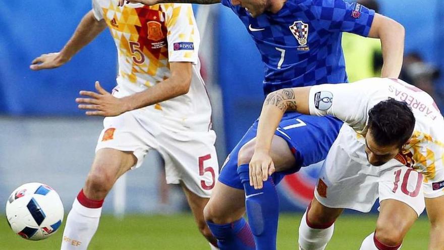 Busquets y Cesc intentan frenar a Rakitic durante el partido de ayer ante Croacia.