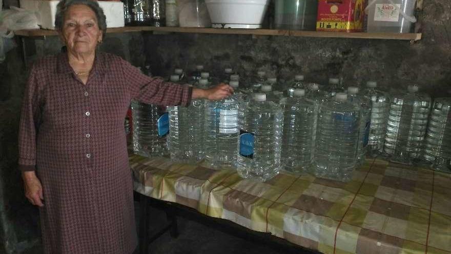 Vecinas de Arcillera reciben las garrafas de agua potable.