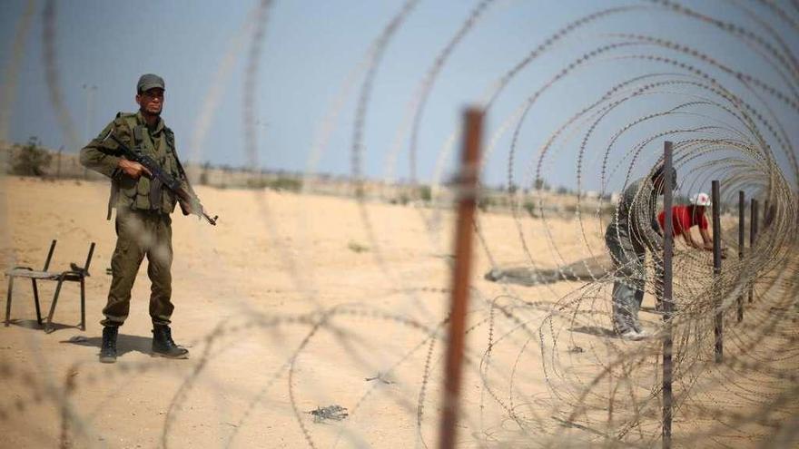 Un miembro de la seguridad palestina, leal a Hamás, hace guardia en la frontera con Egipto. // Reuters