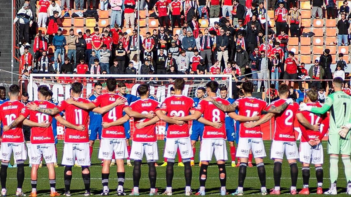 Jugadores del Nàstic, guardando un minuto de silencio