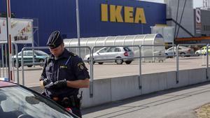 Un agent parla amb uns clients als afores de l’Ikea de Vasteras, a Suècia.