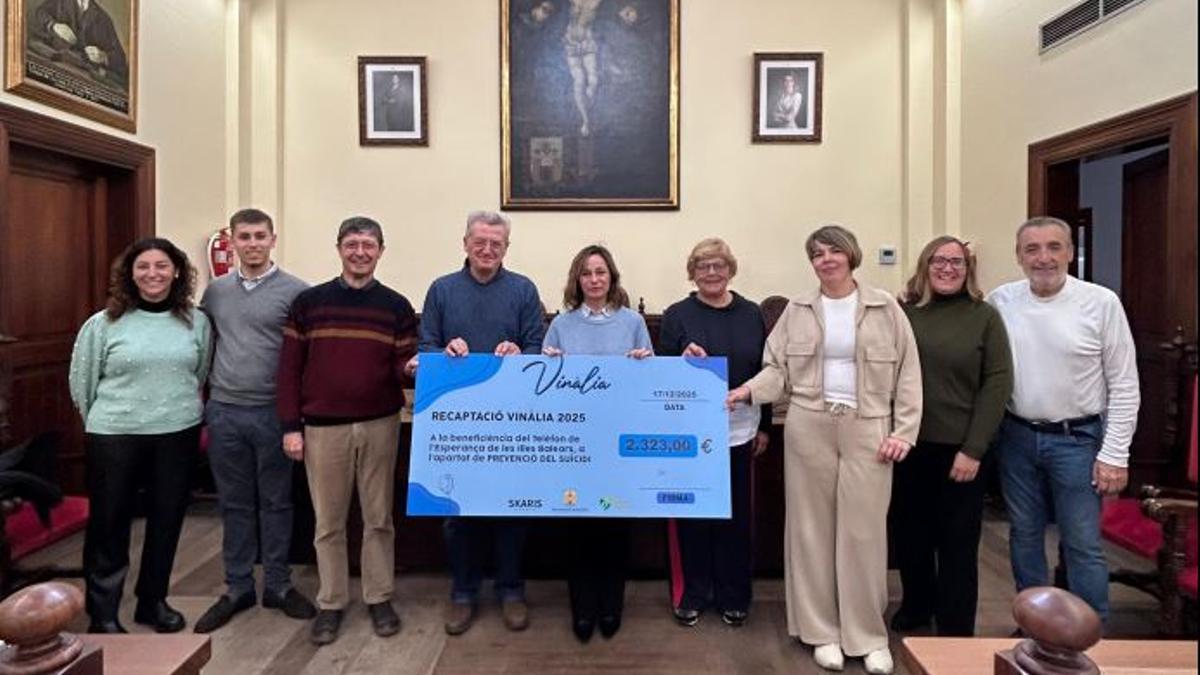 Autoridades y representantes del Teléfono de la Esperanza posan con el cheque en la sala de plenos municipal.