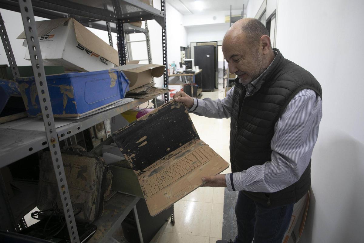 Germán García, con un ordenador que estaba el día de la dana en su tienda Snollocer Informática de Sedaví.