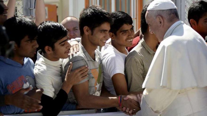 El Papa habla con unos jóvenes refugiados en el puerto de Mitilene, en la isla de Lesbos. // Reuters