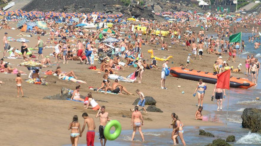 Una gran cantidad de turistas disfruta en una de las playas de Lanzarote.