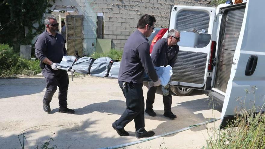 Operarios de los servicios funerarios trasladan, ayer, el cadáver de la víctima del crimen en Eivissa.