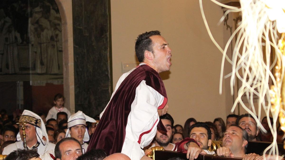 Salvador Porlán Chuecos, costalero del San Juan del Paso Blanco, grita vítores a la imagen mientras es alzado en alto desde los varales del trono.