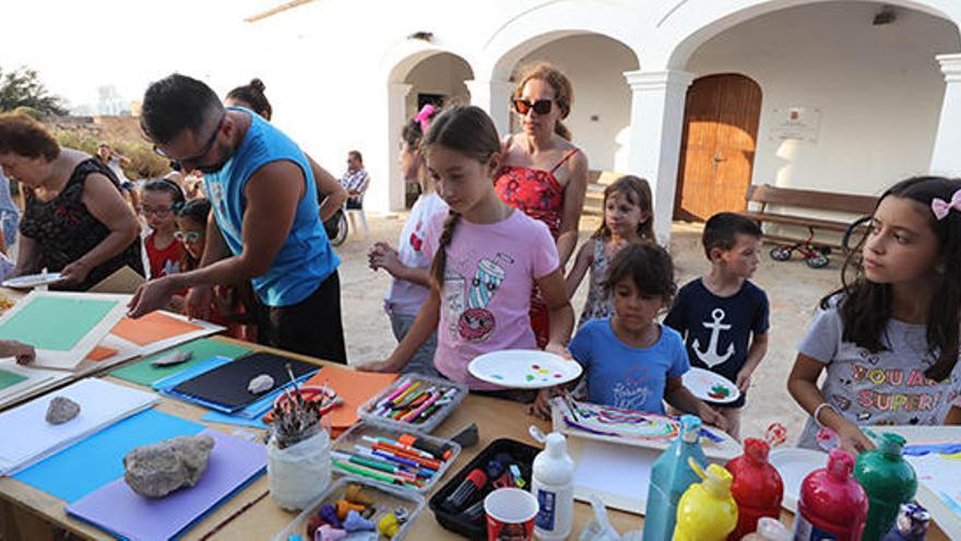 Los jóvenes asistentes se dirigen a la mesa para coger una cartulina y pinturas.