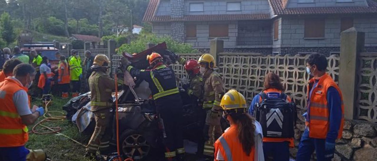 Los servicios de emergencia en el lugar del accidente durante la maniobra para rescatar a los jóvenes atrapados en el coche | // G.N.