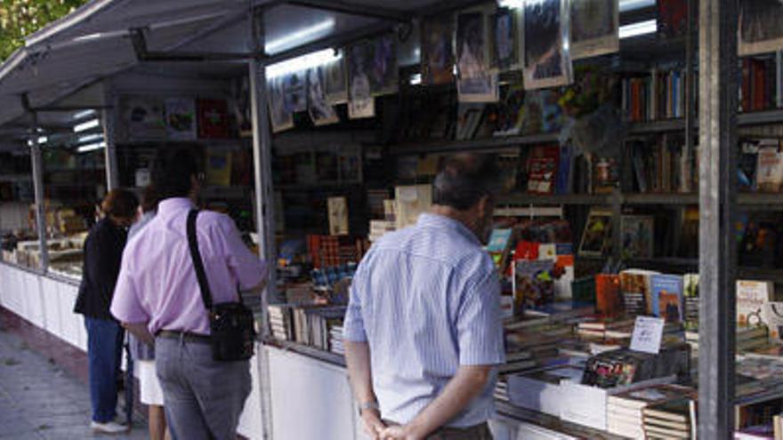 Varios zamoranos observan los libros que ofrece la muestra.