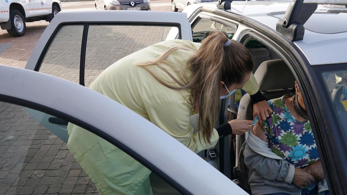 Una enfermera vacunando a una persona con movilidad reducida en un coche en la Cidade da Cultura de Santiago