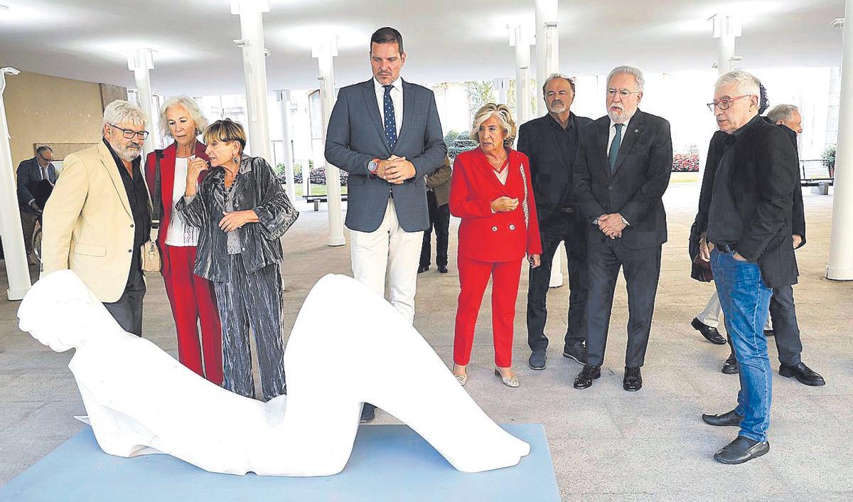 Artistas y autoridades observan una escultura, durante una visita guiada por O Hórreo