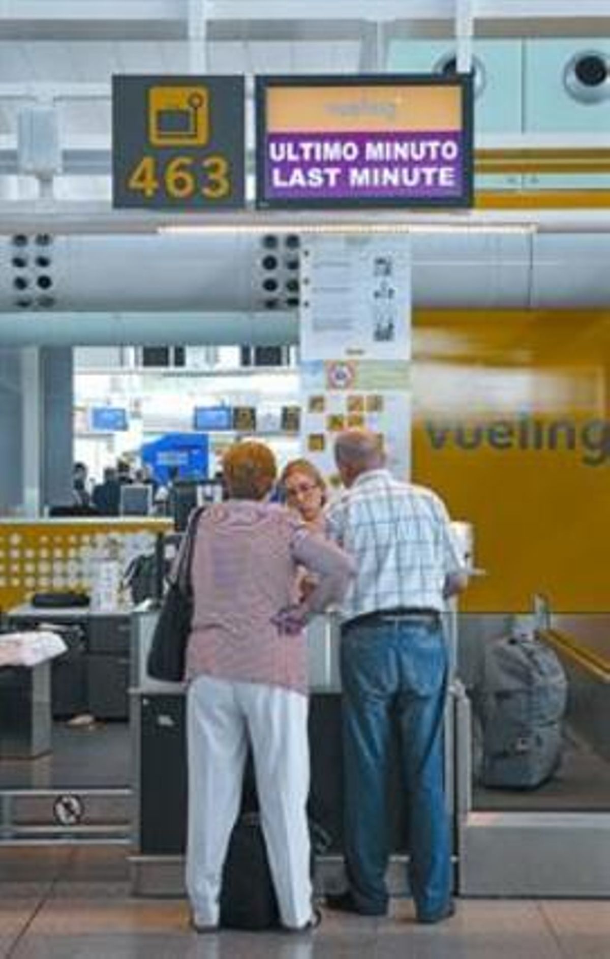 Dos passatgers de Vueling facturen equipatge a l’aeroport del Prat.