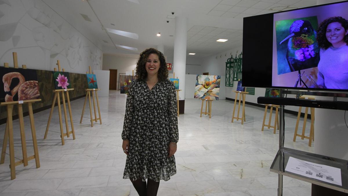 La artista y trabajadora del aeropuerto Mónica Suárez, junto a sus obras en la sala de exposiciones de al T2 del Aeropuerto Cesar Manrique-Lanzarote.