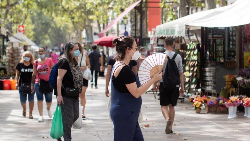 Gente pasea por la Rambla de Barcelona.