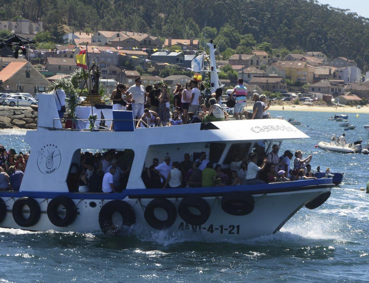 1. La Virgen del Carmen en el barco «Camboño» saliendo del puerto. 2. Numerosas embarcaciones y motos de agua en la procesión. 3. Danzas tradicionales en el atrio de la iglesia parroquial de Aldán. 4. Procesión terrestre entre el templo y el muelle, tras la misa y antes de que la imagen embarcase. | GONZALO NÚÑEZ