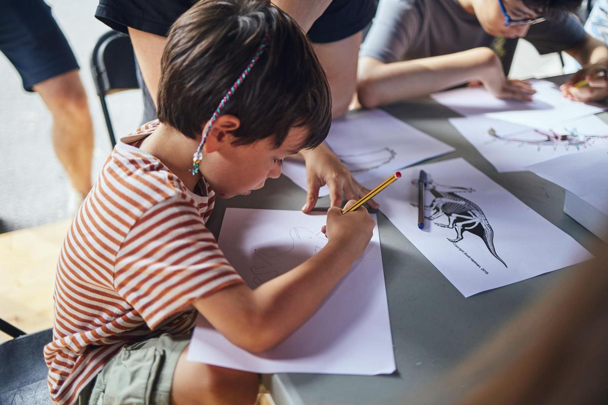 Un niño dibuja un dinosaurio durante un casal de verano