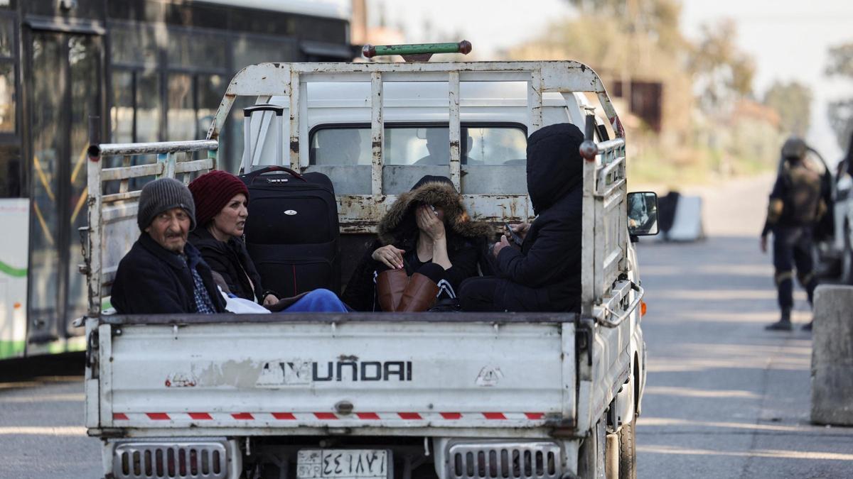 Una familia alauita siria monta en un camión para volver a casa, en Latakia.