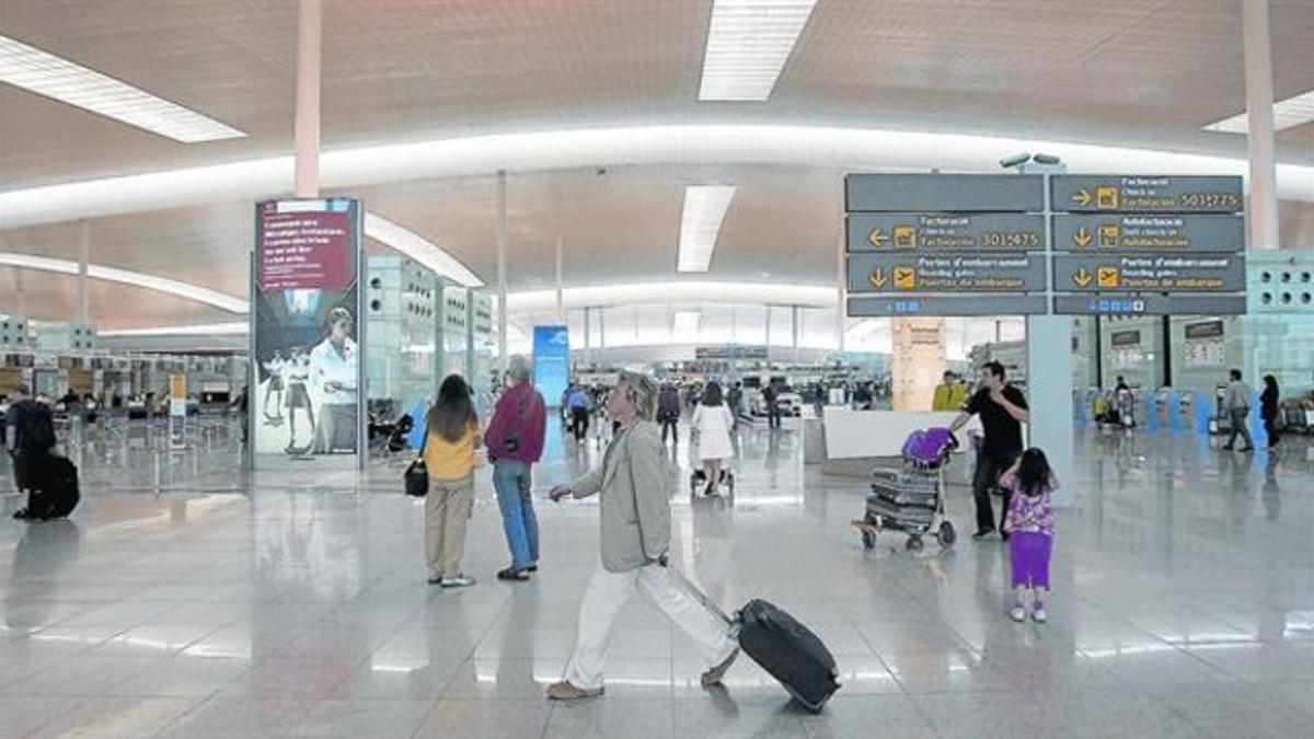 Varios pasajeros se distribuyen por la zona de facturación de equipajes de la terminal T-1 del aeropuerto de Barcelona-El Prat, en el 2010.