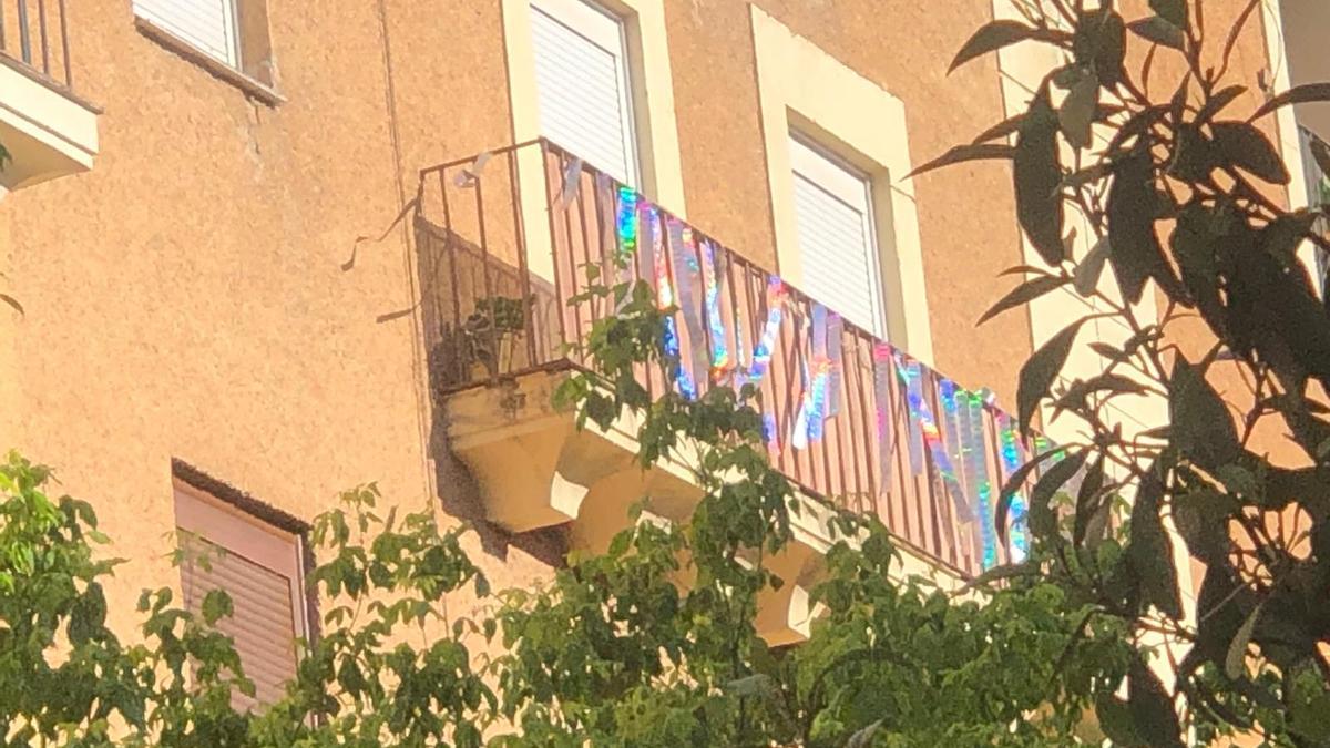 Balcón de una fachada en Cáceres con cintas reflectantes para ahuyentar a las palomas