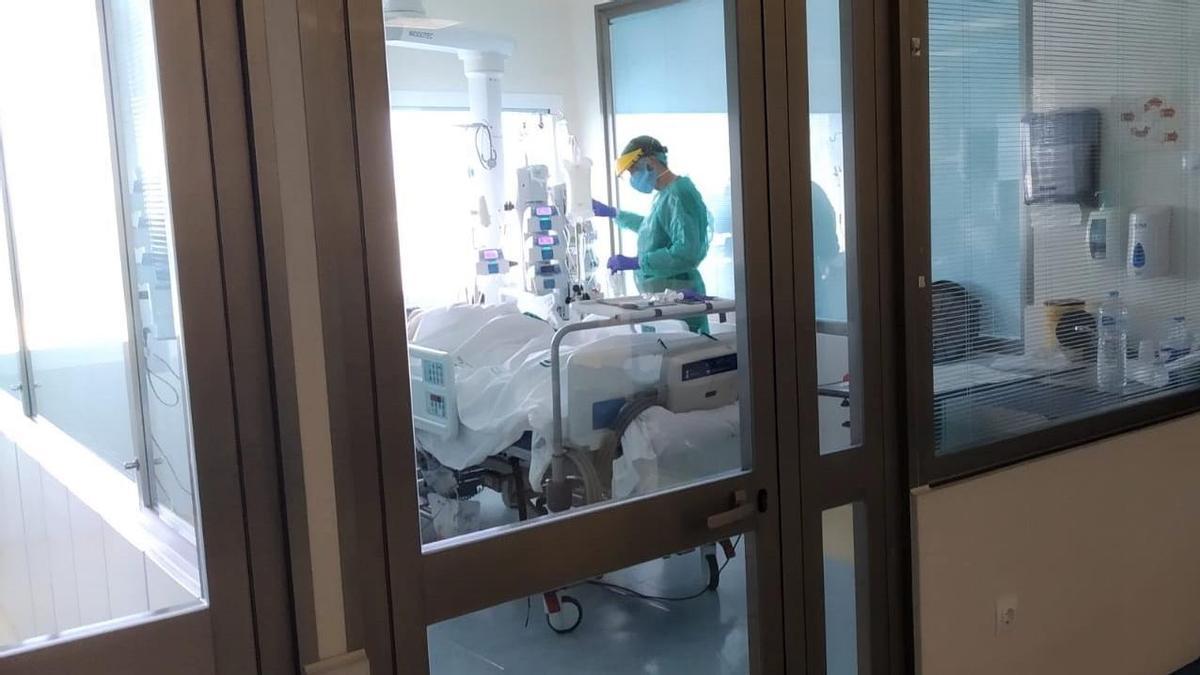 Un sanitario atiende a un paciente ingresado en la UCI de un hospital andaluz.