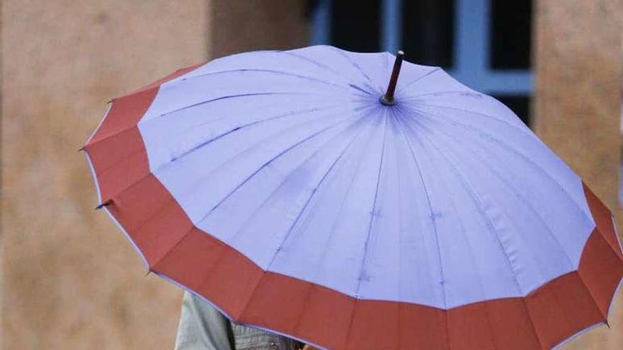 Una mujer pasea por las calles de Oviedo bajo su paraguas.