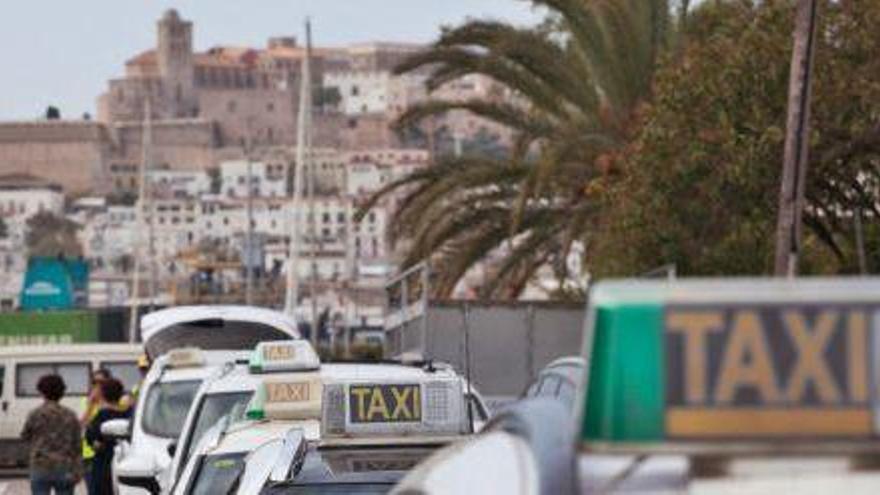 Fila de taxistas en la parada de la estación marítima de Formentera, con la vista de Dalt Vila al fondo.