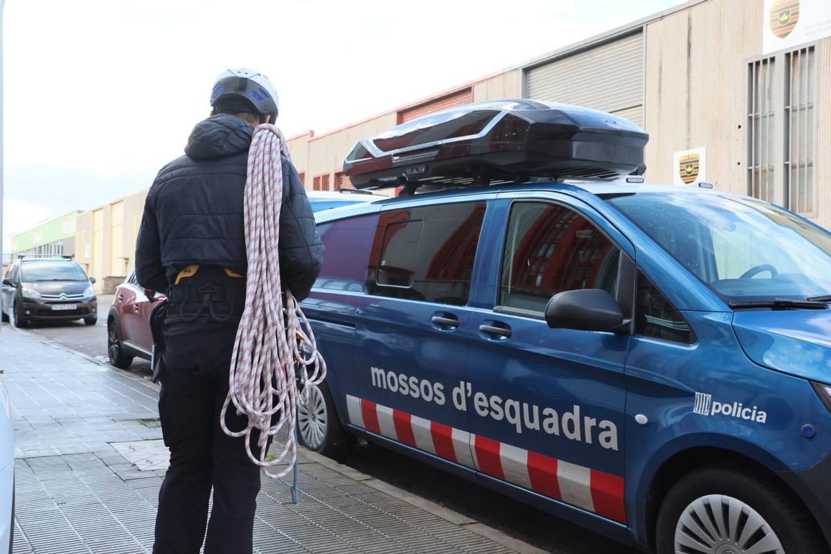 Un efectiu de la Unitat de Muntanya dels Mossos sortint de la nau on ha passat l'accident