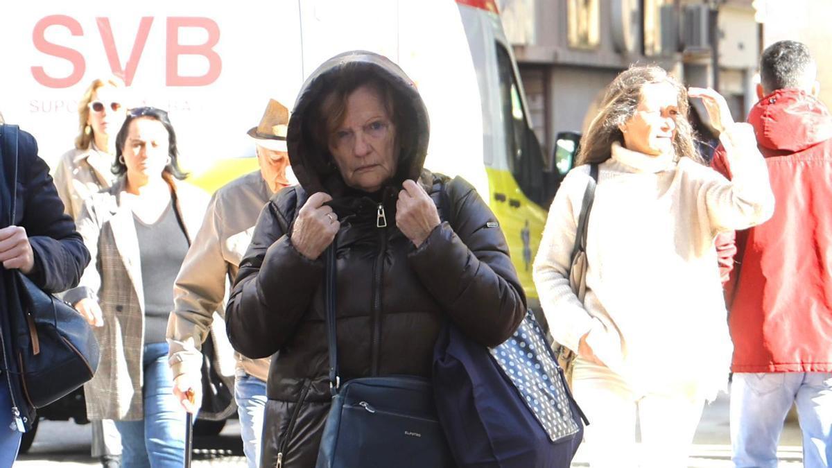 Una mujer se cubre del frío en Alicante