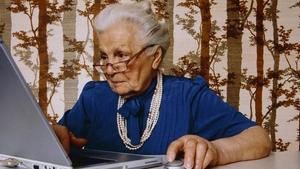 Una señora mayor utilizando el ordenador. 