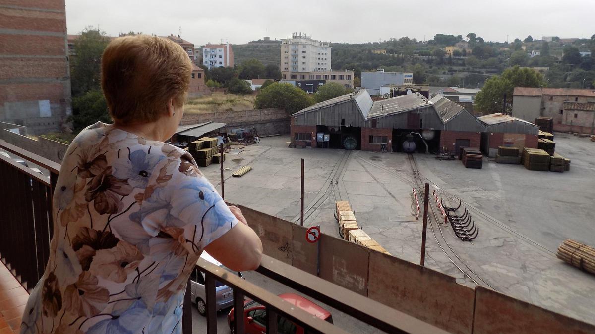 Una vecina mira desde su casa las instalaciones de la empresa PYMSA, en el barrio de Valldaura de Manresa.