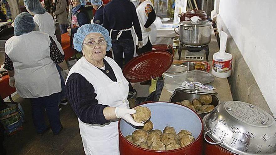 En la foto superior dos mujeres recogen su ración, mientras que abajo, una de las cocineras muestra los bolos do pote. // Santos Álvarez