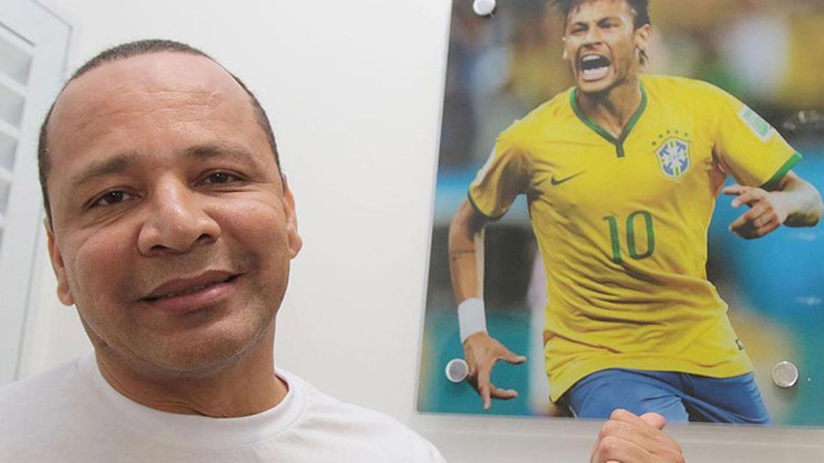 Neymar padre, junto a una foto de su hijo