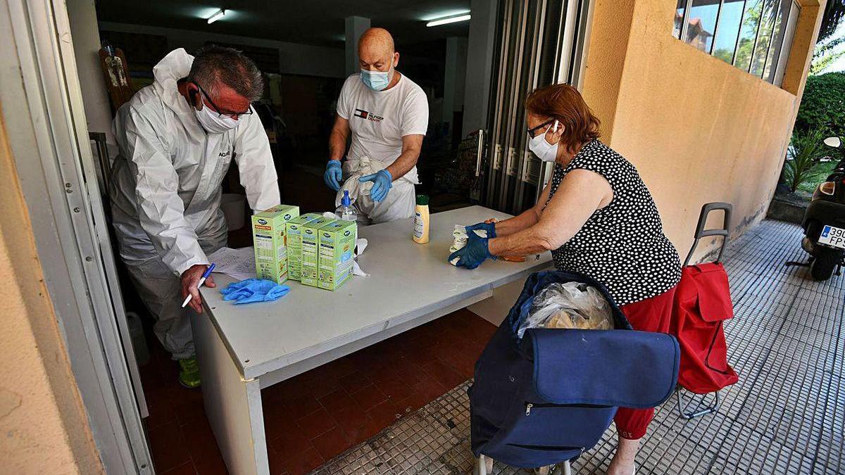 Trabajadores de una ONG entregan alimentos a una mujer durante el estado de alarma.