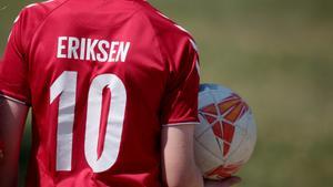 Un joven fanático de la selección danesa con la camiseta de Eriksen jugando un partido fuera del estadio antes del choque entre Dinamarca - Bélgica